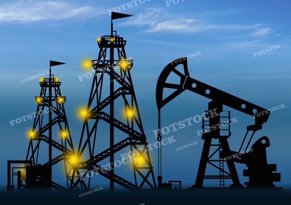 На фотографии запечатлены силуэты нефтедобывающих установок на фоне сумеречного или раннего утреннего неба. На переднем плане видна нефтяная насосно-компрессорная установка, часто называемая качалкой, и две нефтяные буровые вышки, освещенные яркими огнями. Такой снимок может быть использован в статьях и презентациях, касающихся нефтедобычи, энергетической отрасли и их роли в экономике, а также для обсуждения работы и механизмов добычи нефти.